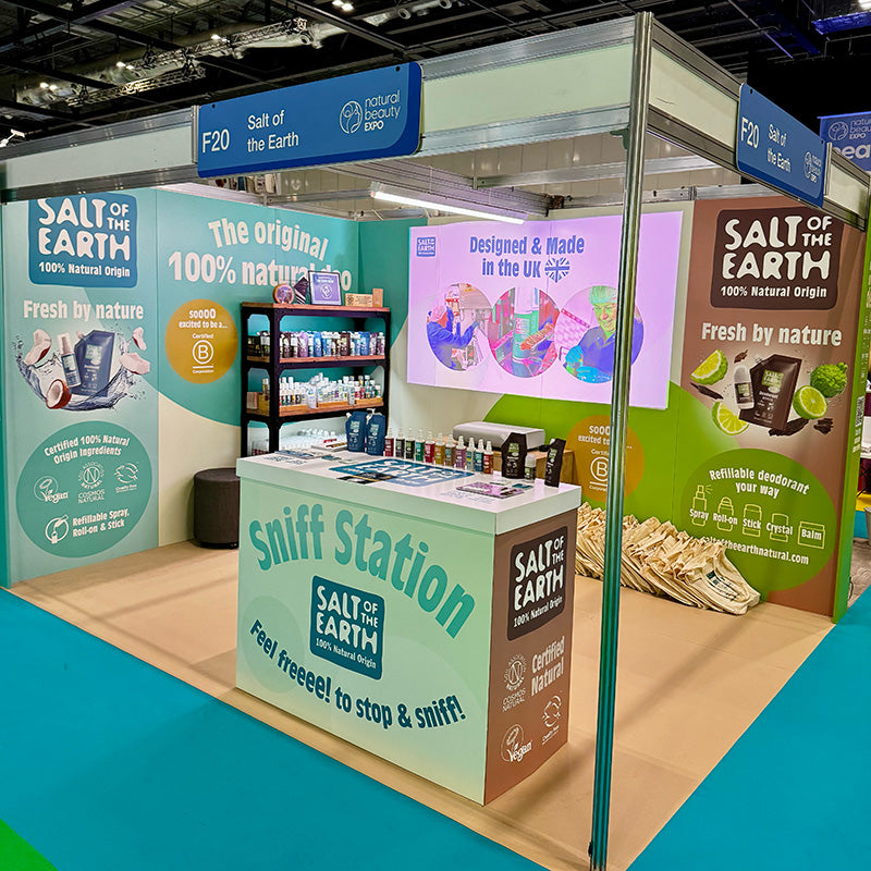 Salt of the Earth completed exhibition stand at NOPE 2025, featuring cardboard display panels, our sniff station, product shelving, certification logos, and 100% natural origin messaging alongside our B Corp certification.