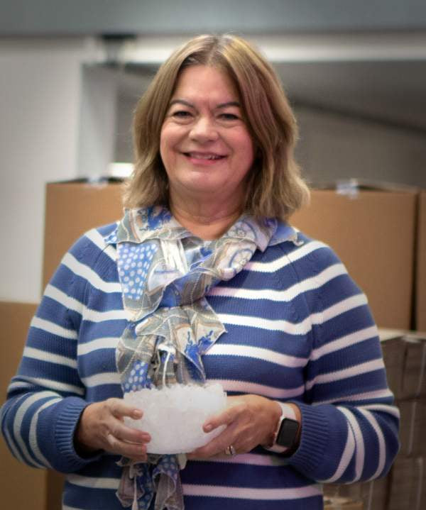 Sally from Salt of the Earth team holding a large natural deodorant crystal at the production facility